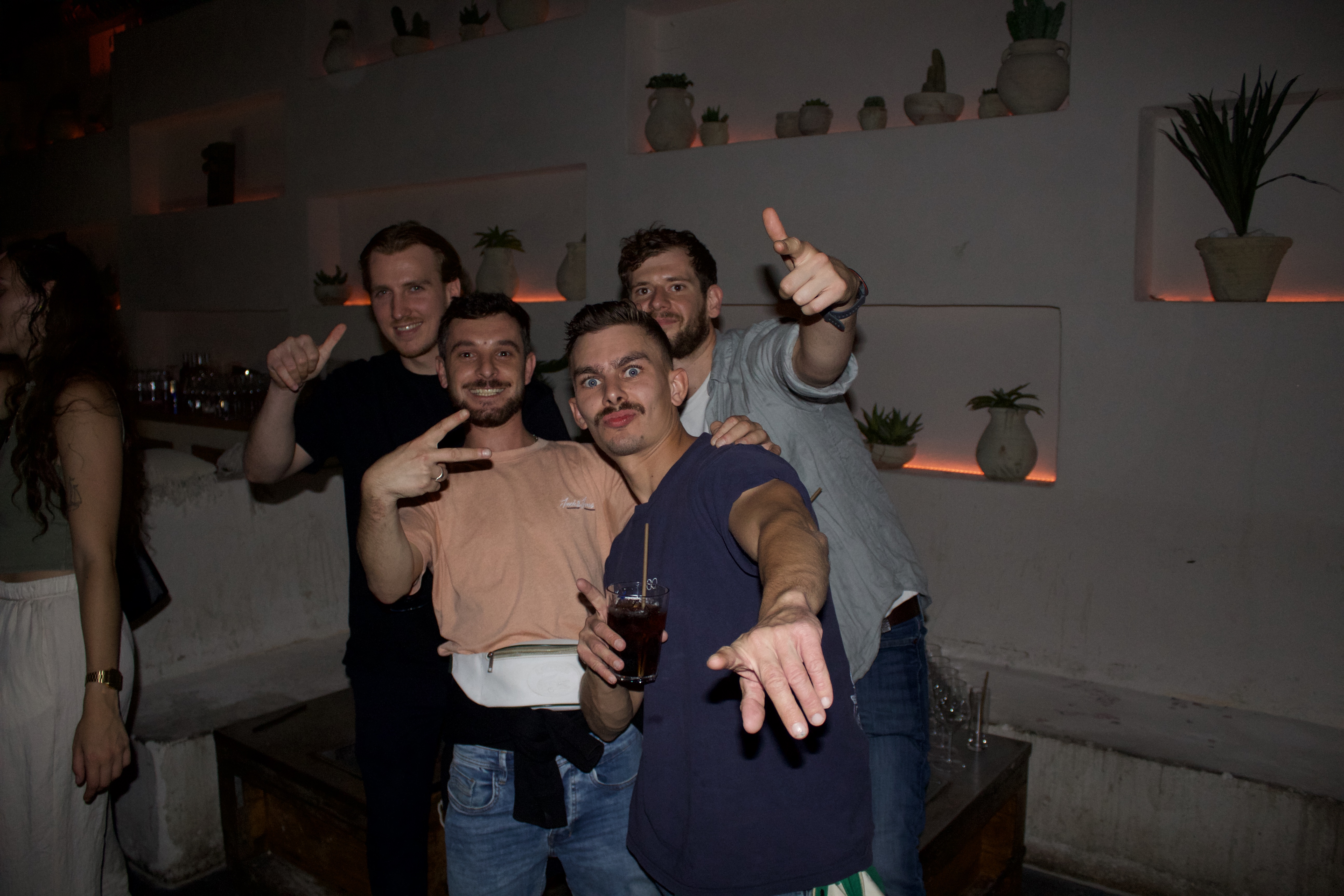 Groupe de 4 amis tapent la pose de manière humoristique dans une salle très tamisée